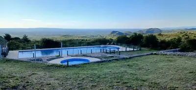 a swimming pool on a hill with mountains in the background at El Paraíso de las Chacras in Las Chacras (La Paz)