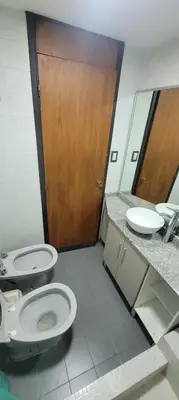 a bathroom with two toilets and a wooden door at Departamento Plaza San Martín in Cordoba