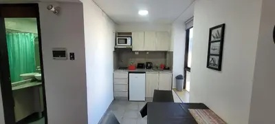 a small kitchen with white cabinets and a table at Departamento Plaza San Martín in Cordoba