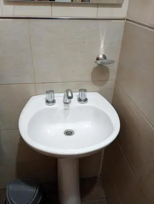 a white sink in a bathroom with a mirror at La Carolina Cabañas in Almafuerte