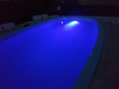 a large blue swimming pool in a dark room at La Carolina Cabañas in Almafuerte
