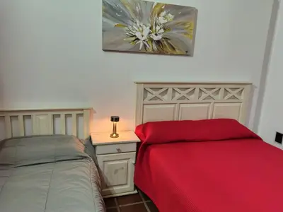 a bedroom with a bed and a desk with a red blanket at La Carolina Cabañas in Almafuerte