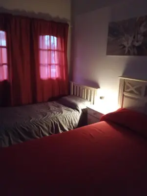 a bedroom with two beds and two windows at La Carolina Cabañas in Almafuerte