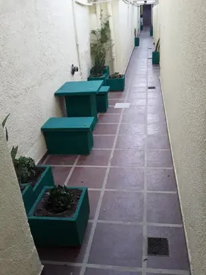 a hallway with green benches and plants on the floor at El Dpto de Gabicito V in Cordoba