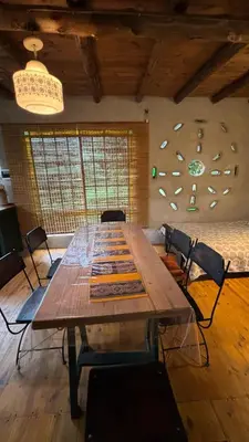 a large wooden table in a room with chairs at Tierra de Arroyo, Mallin-Tanti in Tanti