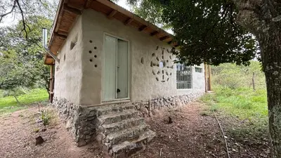 a stone building with a door and a window at Tierra de Arroyo, Mallin-Tanti in Tanti