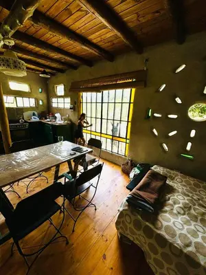 a room with a table and chairs and a woman in a kitchen at Tierra de Arroyo, Mallin-Tanti in Tanti