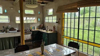 a kitchen with a table and some windows at Tierra de Arroyo, Mallin-Tanti in Tanti