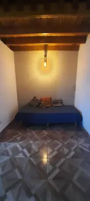 a bedroom with a blue bed in a room with a tiled floor at La curva del molino in Villa Parque Siquiman