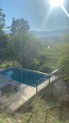 a swimming pool with a table and a bench at La curva del molino in Villa Parque Siquiman