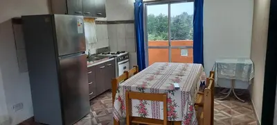 a kitchen with a table and a refrigerator and a window at La curva del molino in Villa Parque Siquiman