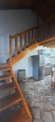 a kitchen with a wooden staircase and a refrigerator at La curva del molino in Villa Parque Siquiman