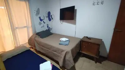 a small room with a small bed and a television at El Rincón de Siquiman in Villa Parque Siquiman
