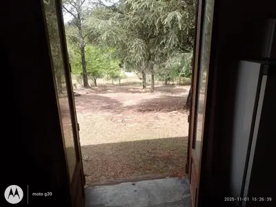 an open door with a view of a yard at CASA ANTONIO-sobre el rio in Villa Carlos Paz