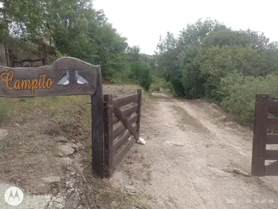 a sign for the entrance to a dirt road at CASA ANTONIO-sobre el rio in Villa Carlos Paz