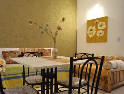 a dining room table with chairs and a vase with flowers at Apartamento del Sol para 5 in Villa Carlos Paz