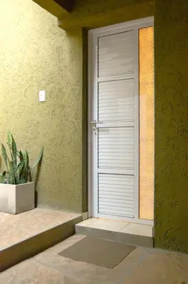 a door in the side of a building with a plant at Apartamento del Sol para 5 in Villa Carlos Paz