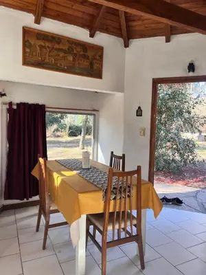 a dining room with a yellow table and chairs at Casita de campo in Villa Ciudad Parque