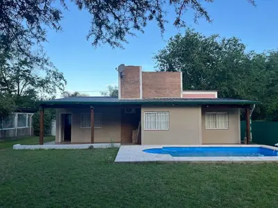 a small house with a pool in front of it at Cabañas El Chañar in Villa Santa Cruz del Lago