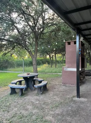 a picnic table and two benches under a tree at Cabañas El Chañar in Villa Santa Cruz del Lago
