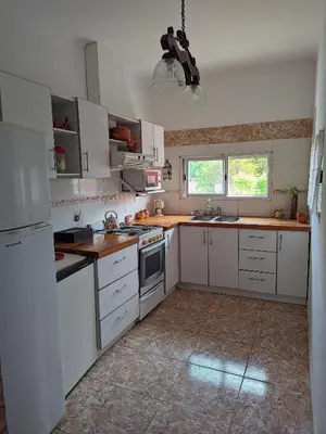 a kitchen with white cabinets and white appliances at Luna Vallista House in Mina Clavero