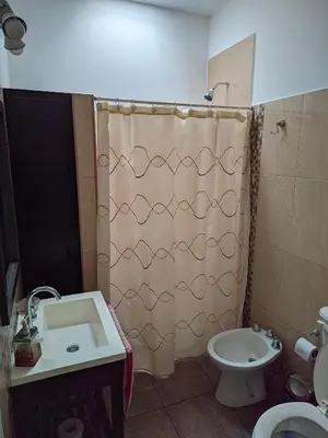 a bathroom with a shower curtain and a sink at Luna Vallista House in Mina Clavero