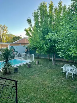 a yard with a pool and chairs and a tree at Luna Vallista House in Mina Clavero