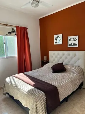 a bedroom with a large bed with a red wall at Luna Vallista House in Mina Clavero