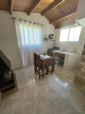a living room with a table and a kitchen at Lo del Turco in La Porteña