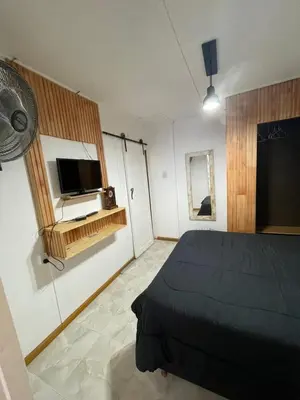a bedroom with a bed and a flat screen tv at Lo del Turco in La Porteña