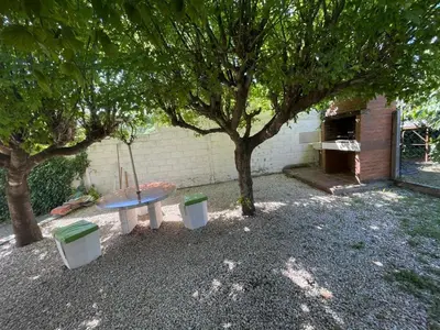 a picnic table under a tree next to a building at Lo del Turco in La Porteña