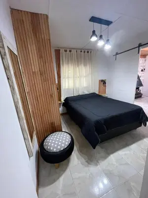 a bedroom with a black bed and a stool at Lo del Turco in La Porteña