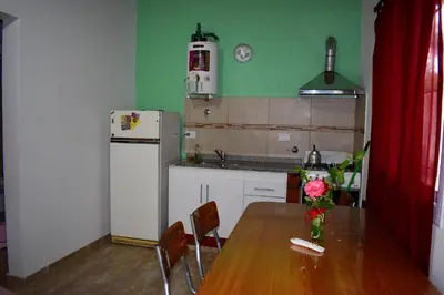 a kitchen with a wooden table and a refrigerator at Sierras Del Molle in Santa Rosa de Calamuchita