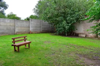 a wooden bench sitting in a yard next to a fence at Sierras Del Molle in Santa Rosa de Calamuchita