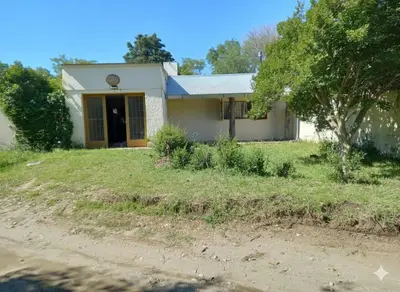 a small white house with a tree in the yard at Casa Amueblada en Las Albahacas in Piedras Blancas