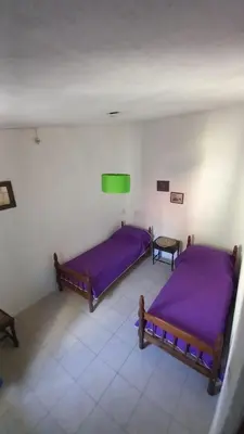 two beds in a room with purple sheets at Casa Amueblada en Las Albahacas in Piedras Blancas