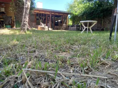 a yard with grass and a table in front of a house at Casa Amueblada en Las Albahacas in Piedras Blancas