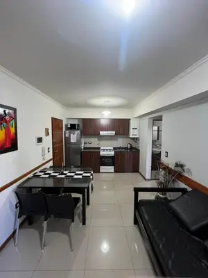 a living room with a couch and a kitchen at Luz del Lago in Villa Carlos Paz