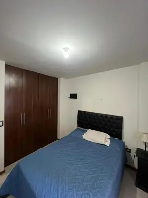 a bedroom with a blue bed and wooden cabinets at Luz del Lago in Villa Carlos Paz