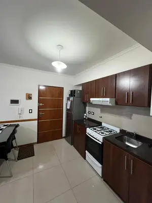 a kitchen with wooden cabinets and a stove top oven at Luz del Lago in Villa Carlos Paz