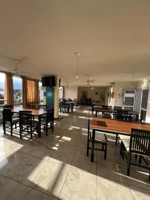 a cafeteria with tables and chairs and a flat screen tv at Luz del Lago in Villa Carlos Paz