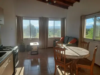 a kitchen and living room with a table and chairs at Bosquemolinos in Villa Los Molinos