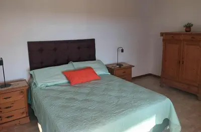 a bedroom with a bed with a red pillow on it at Bosquemolinos in Villa Los Molinos