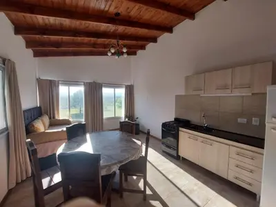 a kitchen and dining room with a table and a couch at Bosquemolinos in Villa Los Molinos
