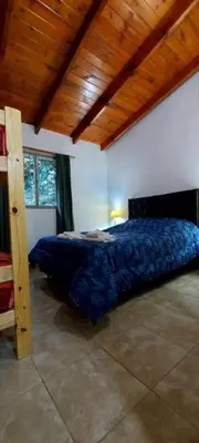 a bedroom with a bed in a room with a wooden ceiling at Cabañas y departamentos Sol y Luna in Villa General Belgrano