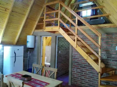 a wooden staircase in a room with a brick wall at Cabañas y departamentos Sol y Luna in Villa General Belgrano