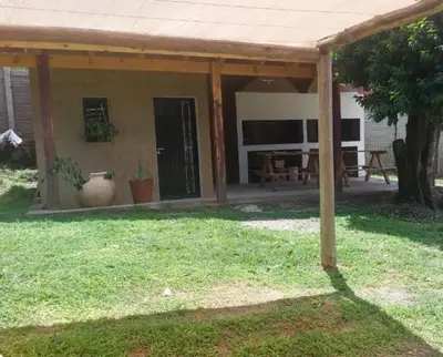 a house with a porch with a table and a patio at Cabañas y departamentos Sol y Luna in Villa General Belgrano