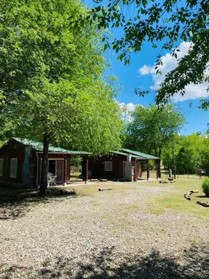 a cabin with a tree in front of it at Cabañas Esmeralda in Villa Ciudad de America