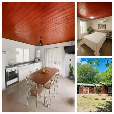 a kitchen with a wooden ceiling and a table with chairs at Cabañas Esmeralda in Villa Ciudad de America