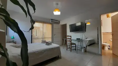 a bedroom with a bed and a tv and a table at Duplex Villa Carlos Paz in Villa Carlos Paz